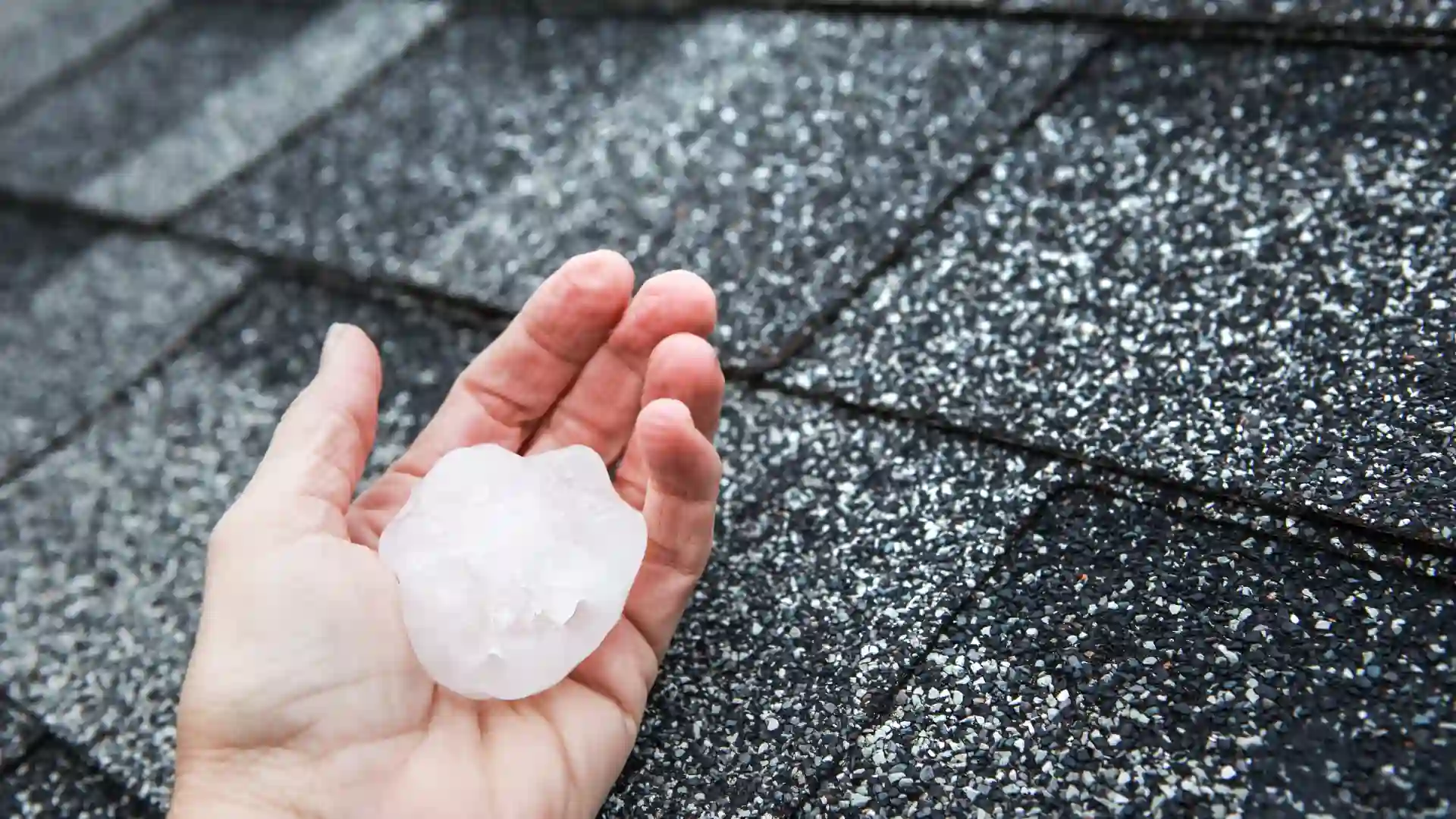 hand with ice on a roof
